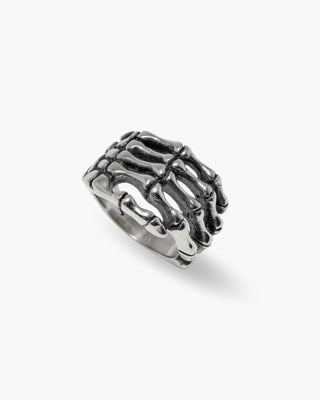 Good Bones ring in stainless steel, skeletal hand wrapped around the finger, angled view
