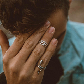 Ti Stack City ring worn: hand covering the face, wearing a stacked silver band and a snake ring