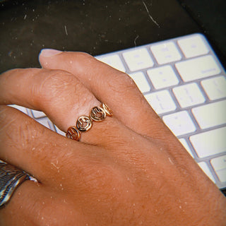 Happy Hour ring worn: hand resting on a keyboard, wearing a gold smiley band