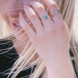 Close-up of a hand wearing thin silver stacking rings