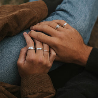 Stacker ring worn: hands resting together, wearing thin stacking bands