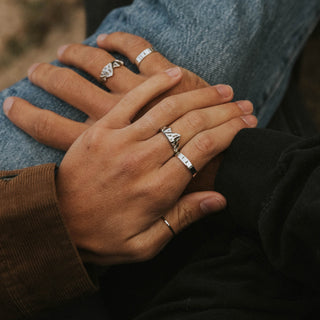 Mt. Ikaika ring worn: hands clasped, wearing silver stacking rings