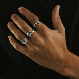 Hug Life ring worn: hand wearing silver rings against a black background