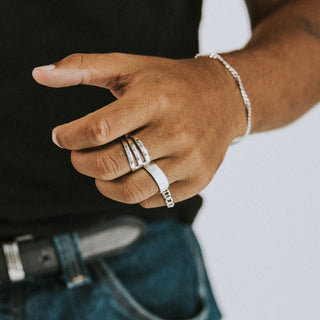 Fork Yeah ring worn: hand with a bracelet wearing a silver Fork Yeah ring and a stacking band